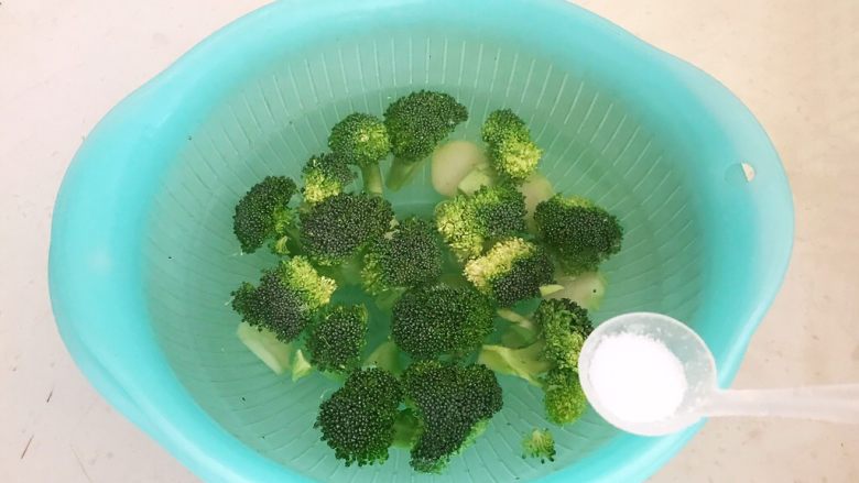 西蓝花炒黑椒牛柳,把西蓝花放入冷水中,加入2克精盐浸泡15分钟
