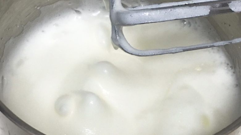 酸奶咖啡蛋糕,用打蛋器高速搅打50圈,蛋白蓬发,打蛋头上出现下垂的弯钩,加入15克细砂糖。