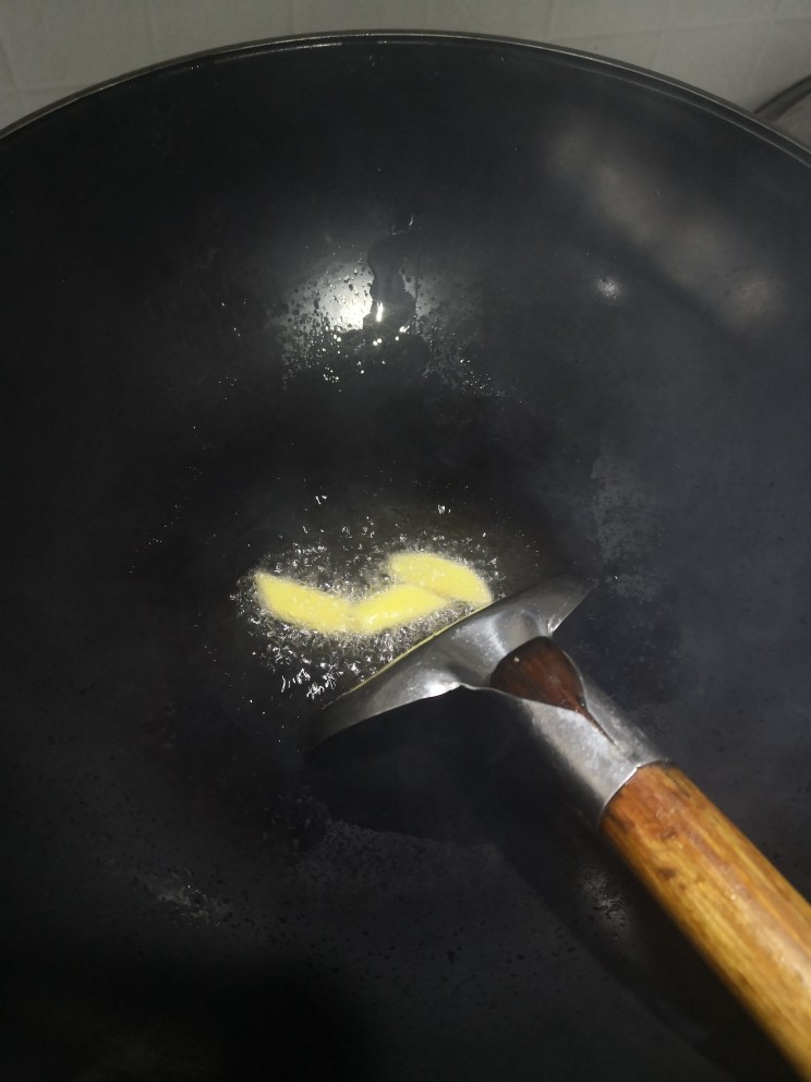 湘味红烧排骨焖土豆,起锅烧油,倒入两姜片。(这里姜片不要炒太老,炒个几十秒钟。)