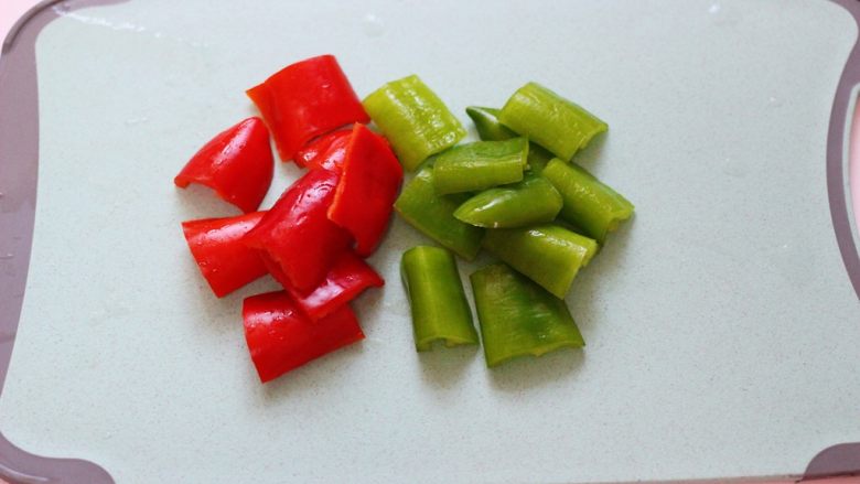 超爽的麻辣孜然烤肉串,这个时候把青红椒洗净后,用刀切成块状。