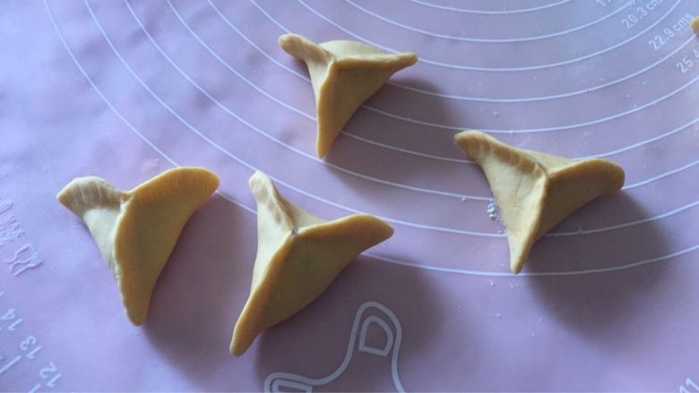 胡萝卜煎饺,将饺子皮捏出三个角成菱形,包好饺子;