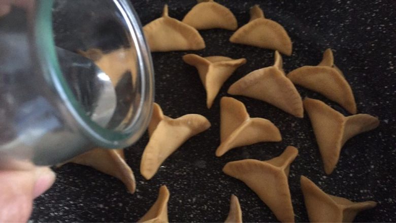胡萝卜煎饺,平底锅放点油烧热,摆入捏好的饺子,小火煎制底部微焦,倒入一小杯清水,盖上锅盖焖几分钟,锅里水分收干以后便可关火。