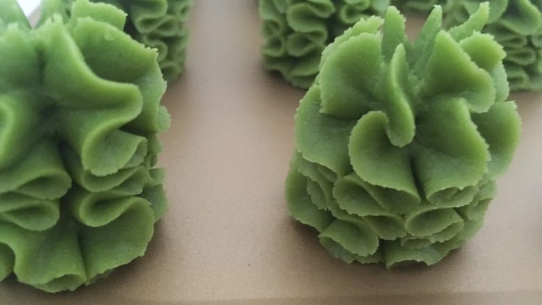 奶香酥脆曲奇,将裱花嘴垂直立于烤盘上,垂直挤出来的面糊会叠加在一起,形成漂亮的珍妮花形,喜欢别的花形的也可以按照自己喜欢的花型来挤
