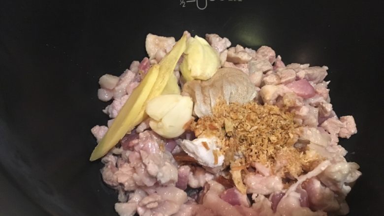 卤肉饭-电锅版,将炒好的猪肉丁放入电锅,加入姜蒜红葱酥