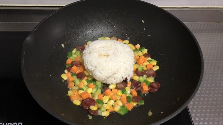 田园腊肠炒饭,倒入米饭,转小火,用铲子不停碾压翻炒