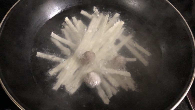 香菇丸子青菜刀削面,水开以后放入面条,盖上锅盖煮至水开,水开以后倒入一碗清水继续盖上锅盖焖煮,反复三次就差不多了。