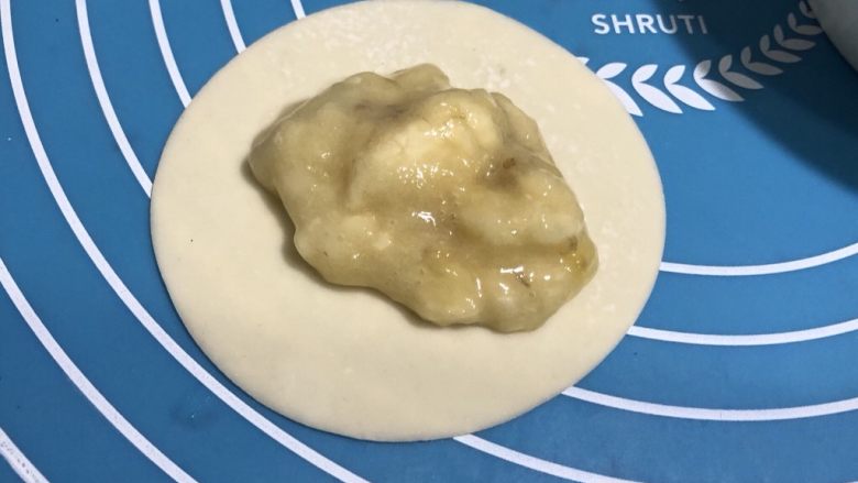 饺子皮香蕉派,铺一张饺子皮,中间摆上适量的香蕉泥,不要太多,要不一会压的时候会溢出来。