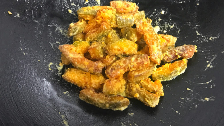 咸蛋黄焗南瓜,倒入炸好的南瓜条,快速翻炒均匀,使蛋黄泥均匀地包裹住南瓜条。