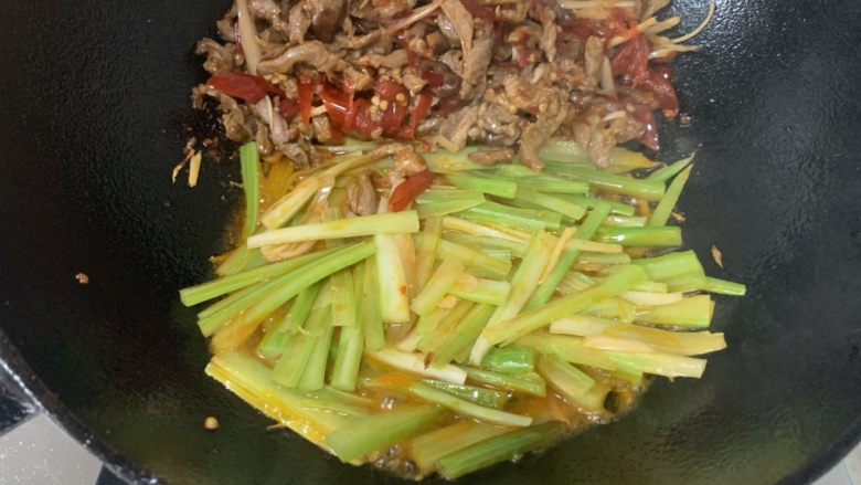 泡椒牛肉牛骨汤面,将泡椒牛肉丝铲在一边,留下热油,倒入芹菜丝继续大火爆炒一下炒熟芹菜。