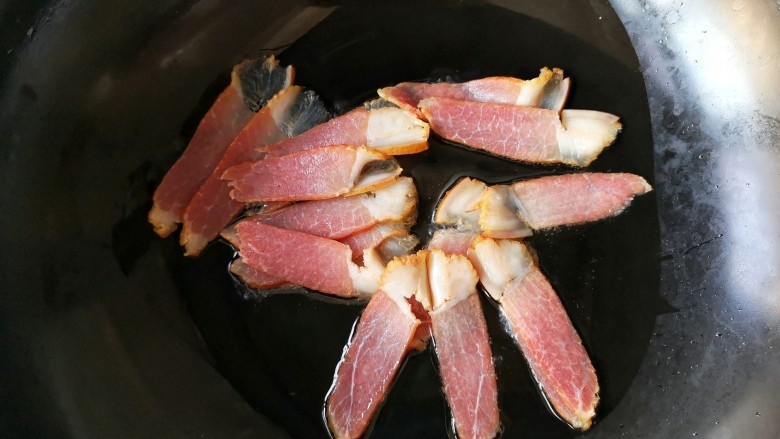 蒜苔炒腊肉,锅中少量油,烧热,放入腊肉。