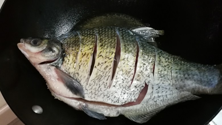 白酒香菜鳊鱼,热锅热油放入鳊鱼大火煎至金黄，晃动锅，鳊鱼在锅中移动再翻面煎