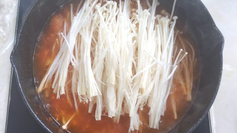 酸汤肥牛,酱汤熬开后加入金针菇,煮5分钟