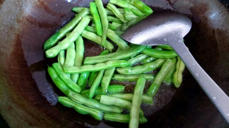 肉沫四季豆,锅中放入适量<a style='color:red;display:inline-block;' href='/shicai/ 857'>植物油</a>,放入四季豆,放少量盐,翻炒