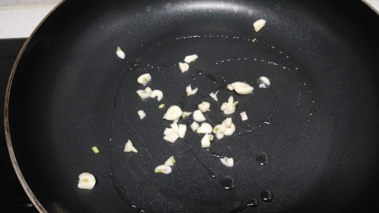 清炒茼蒿,不粘锅中放入少许油,炒香蒜末。