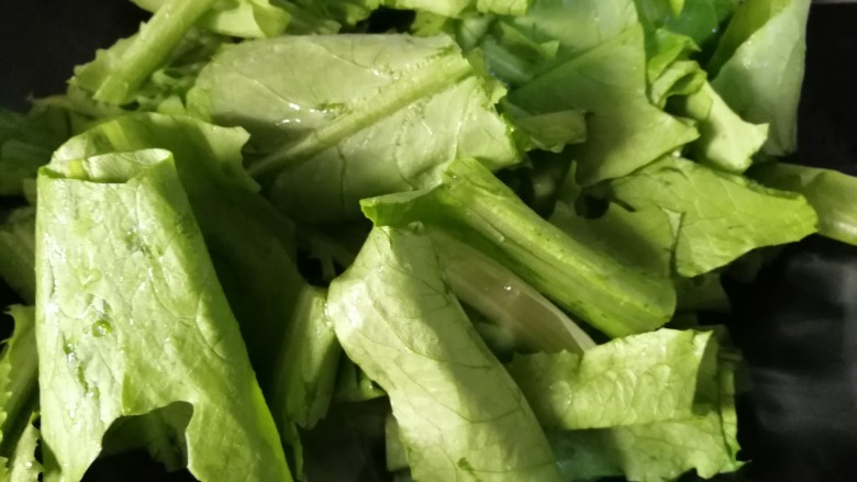 肉炒油麦菜,放入油麦菜,炒一会儿。翻几个个儿油麦菜就可炒熟。
