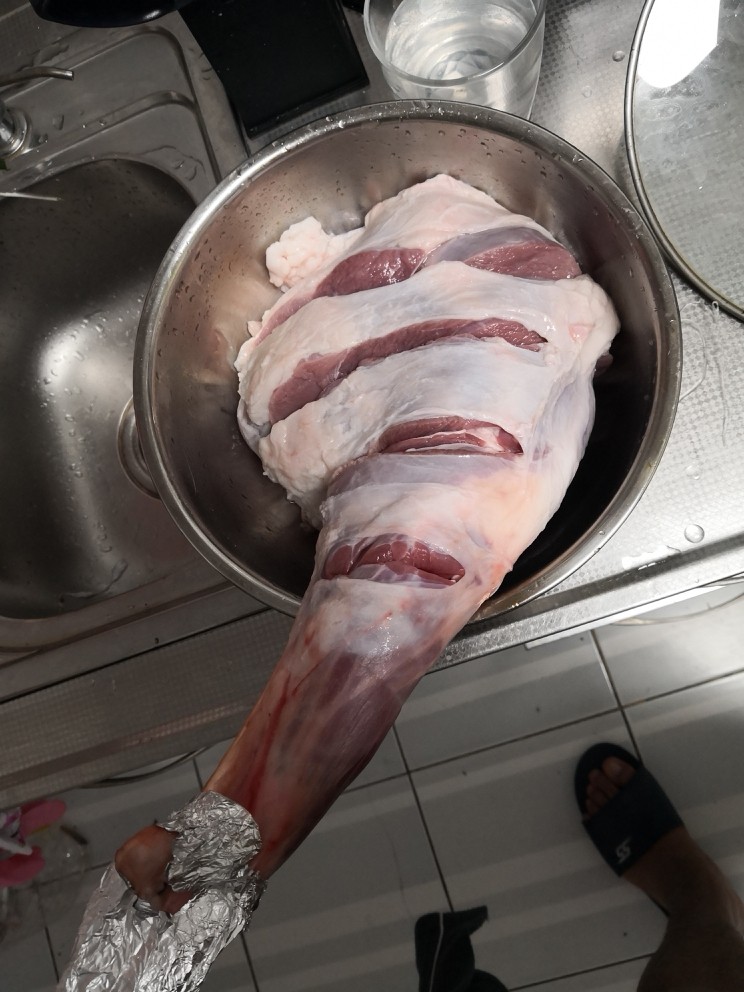 烤羊腿,改斜刀,深至见骨(羊腿背面步骤一致),用清水浸泡两小时,每隔一小时换次水,两小时后沥干水分