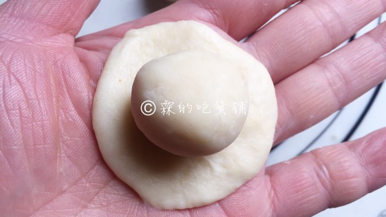 中式菊花酥,松弛好的水油皮面团按扁成圆形,将油酥团放在水油皮面团中