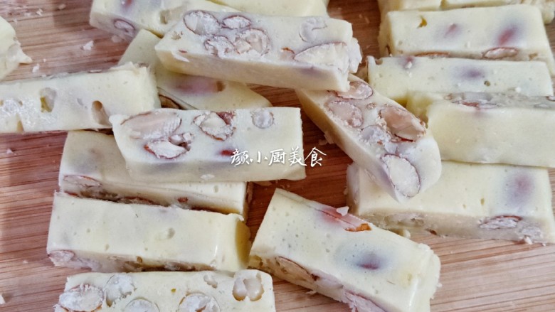 花生杏仁牛轧糖,等牛轧糖彻底凉透了,用刀切成小长条。