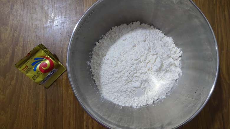 美味看得见的红薯吐司,中种面团:准备面包粉和耐高糖酵母,清水和酵母混合后倒入面包粉中,揉成稍光滑的面团,放入冷藏室发酵10个小时。