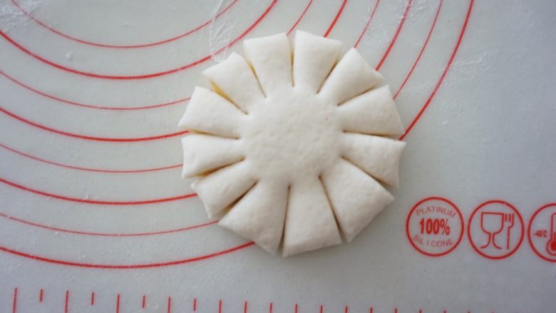 花开富贵馒头,用刮面板沿着周边均匀的切出刀口,刀口长度不要太长,切到面饼的3/5处即可,中央处保留不要切断,形成花瓣状。