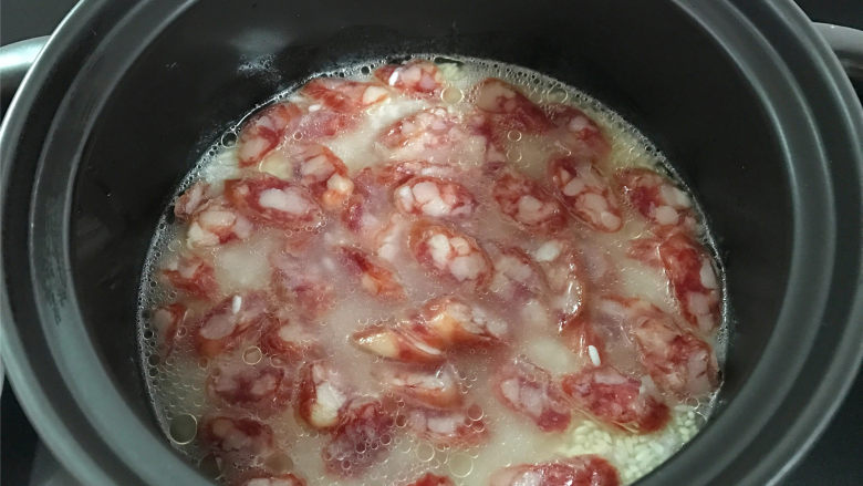 腊肠绣花锦菜饭,然后把切成薄片的腊肠放入锅中,和大米拌匀。