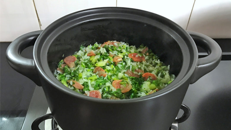 腊肠绣花锦菜饭,把炒好的绣花锦放入锅中和米饭翻拌均匀,再焖2分钟即可熄火。
