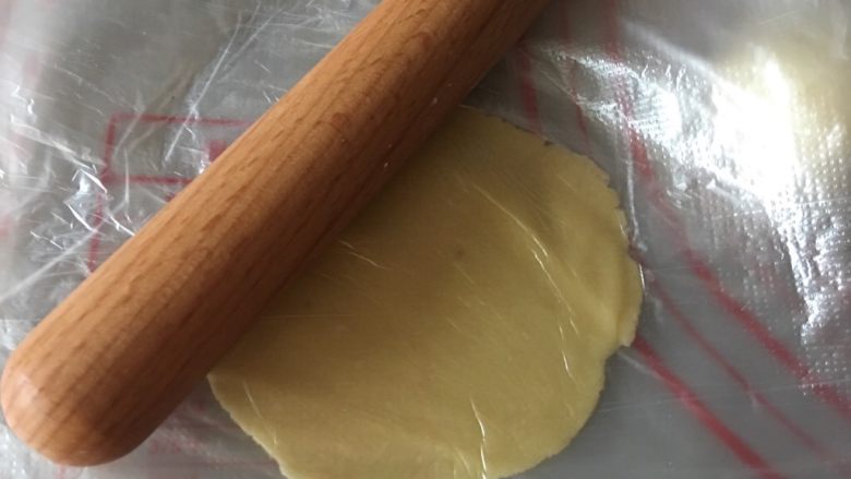 港式酥皮菠萝包,取小油酥面团放入保鲜膜上,上面再盖一层,用擀面杖擀成薄薄的圆面片