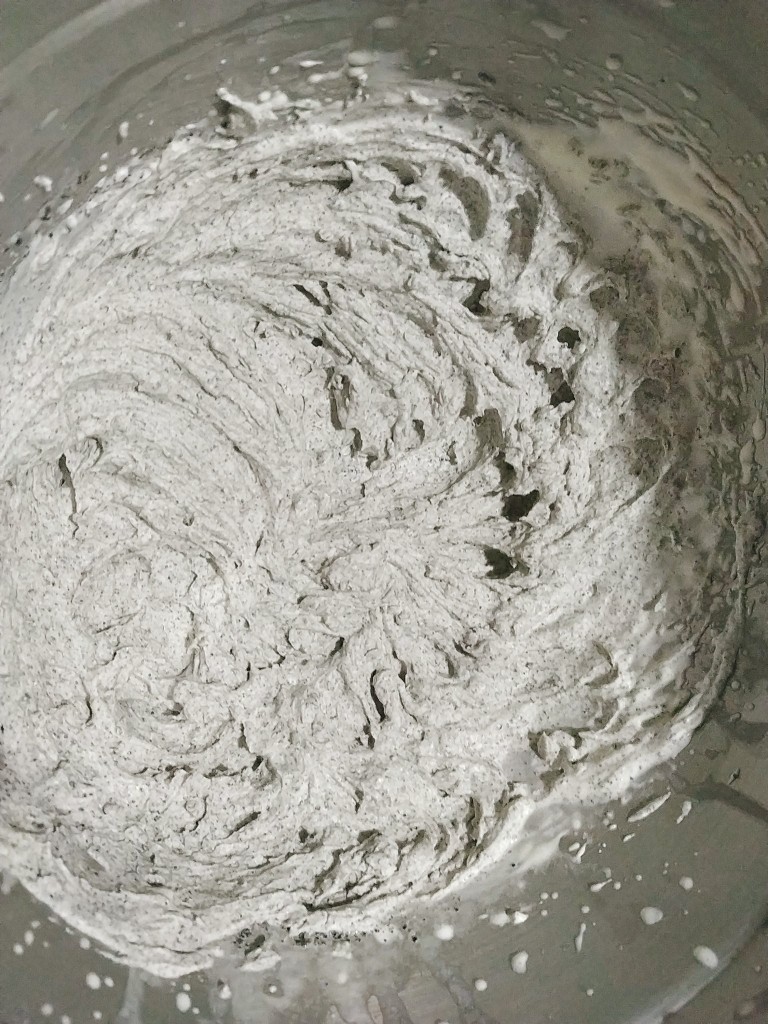 黑芝麻蛋糕卷,先用手持打蛋器手动混合几下淡奶油和黑芝麻粉至无干粉,再开动手持电动打蛋器打发,把黑芝麻淡奶油打发到9分的裱花状态;