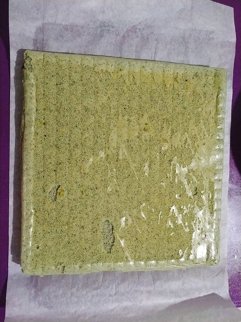 黑芝麻蛋糕卷,把蛋糕卷放在一张比蛋糕卷长一半左右的油纸上面;