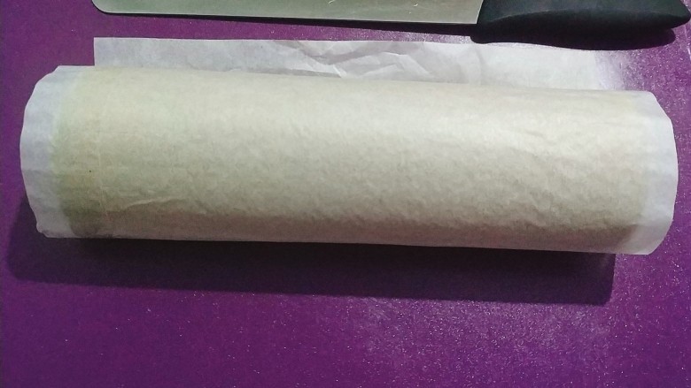 黑芝麻蛋糕卷,把蛋糕卷整个卷起来,用油纸全部包好,放冰箱冷藏一个小时以上;
