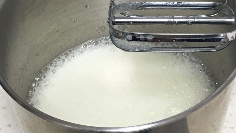 奶油戚风蛋糕,用打蛋器高速搅打30圈,蛋白出现鱼眼泡后加入30克细砂糖。