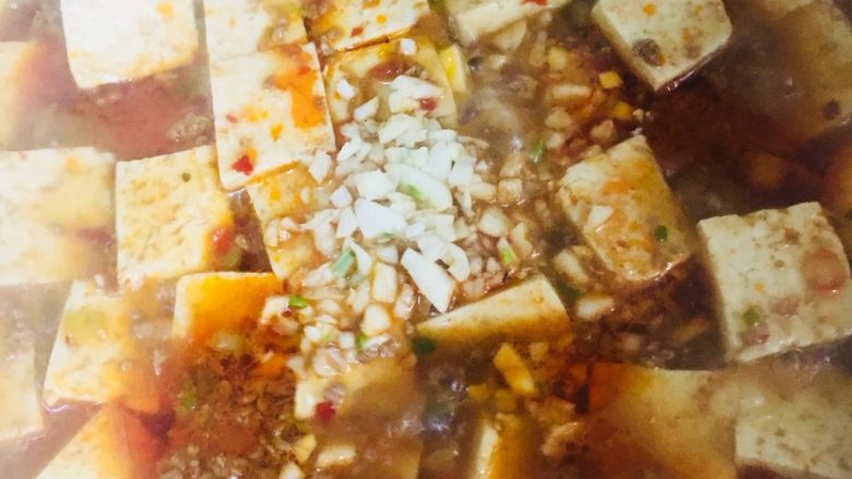 肉末豆腐,放入蒜末,晃动锅子使豆腐和盐、蒜末混合均匀