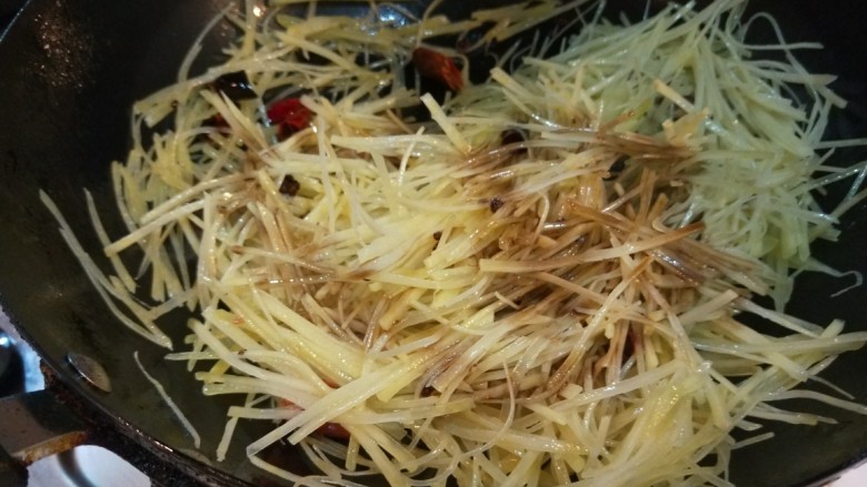 新文美食 酸辣土豆丝,倒入土豆丝炒均匀,倒入适量醋。