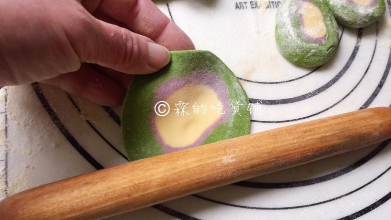 大肉馅的彩虹水饺,左手捏着面皮的边边,转圈,右手拿擀面杖随着左手的转动,把面皮擀圆