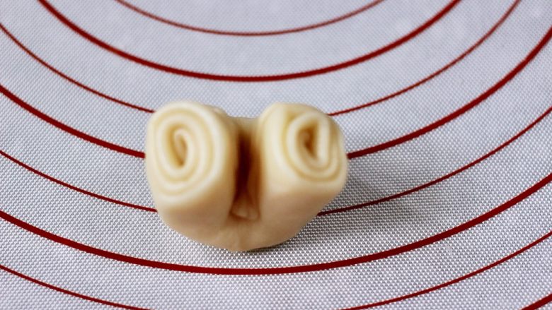 紫薯老婆饼,把松弛好的面卷,取一个从中间对折一下。