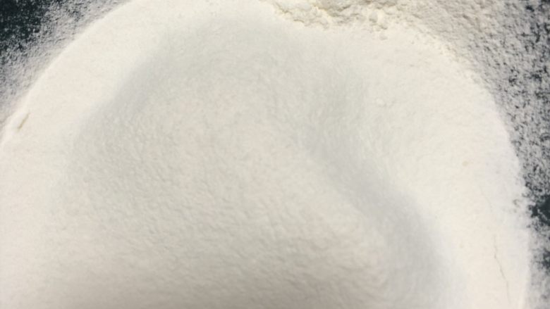巧克力甜甜圈,搅打均匀以后筛入100g面粉和2g左右泡打粉。继续用手抽搅拌均匀,搅拌的时候花z字搅拌,轻一点,防止面糊起筋。