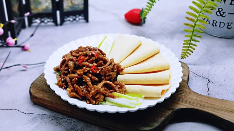 干豆腐皮~京酱肉丝,盛入摆放好的京葱和干豆腐皮盘中,撒上熟<a style='color:red;display:inline-block;' href='/shicai/ 678'>白芝麻</a>。