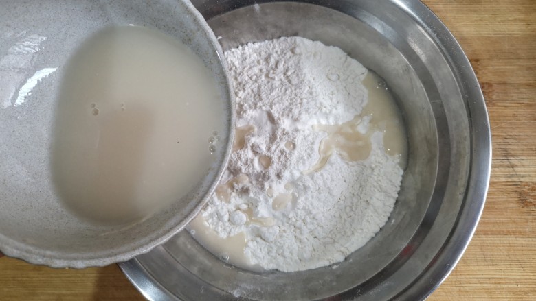 卡通龙猫豆沙包,将酵母粉用温水冲开,少量多次加入白面粉中。