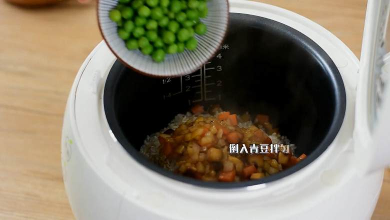 电饭煲懒人饭,还没出锅已经满屋子香味了,电饭煲倒入淘净的大米和煸炒过的蔬菜丁,再倒入青豆拌匀。