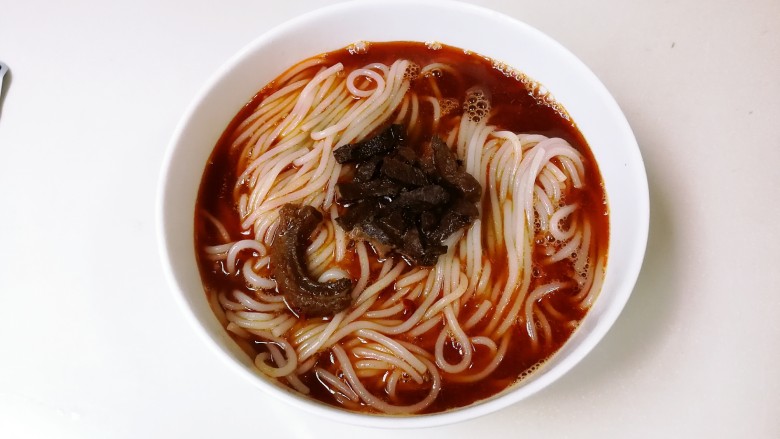 香辣牛杂米粉,剪口香辣牛杂汤包,倒入碗中