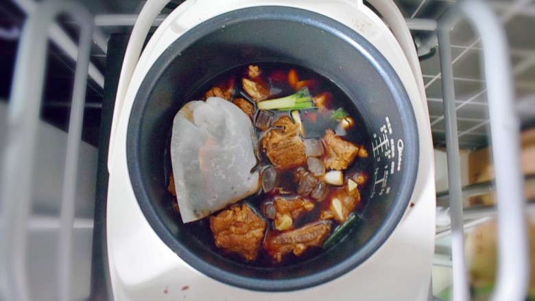 排骨烧山药 (电饭煲版),将腌好的排骨倒入电饭锅,并加入适量的水(水量与排骨的高度持平即可),放入大料袋子。