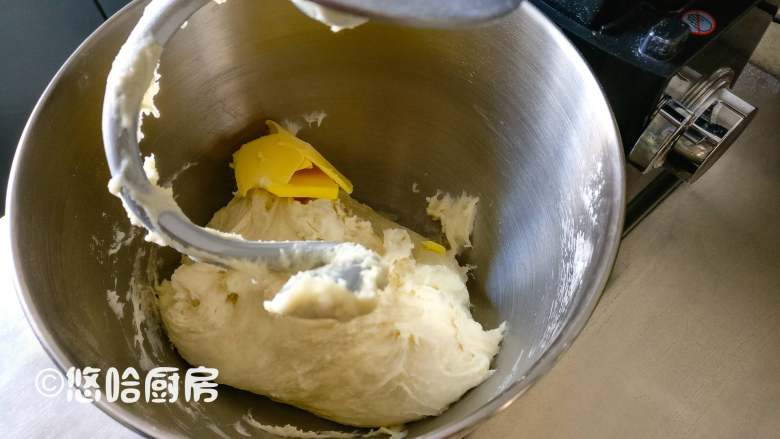 Q感吐司,加入清水和酵母水,用厨师机低速搅拌5分钟,中速搅拌5分钟,加入室温下软化的黄油,继续搅打面团。