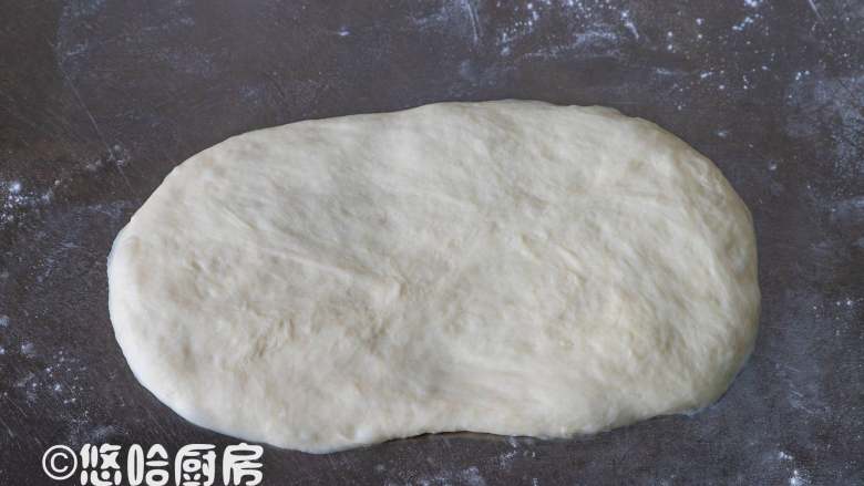 Q感吐司,取一个醒发后的面团,拍扁翻面擀开长长圆形。