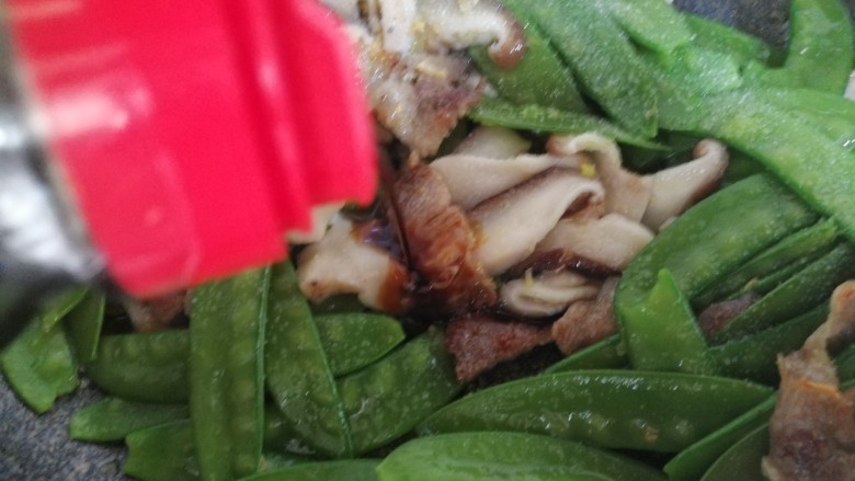 肉炒荷兰豆香菇,倒入适量的<a style='color:red;display:inline-block;' href='/shicai/ 692'>酱油</a>,改大火翻炒几下。