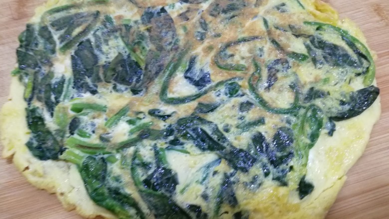 菠菜鸡蛋饼(无面粉),煎好后,放在菜板上,用刀切三角块,装盘。