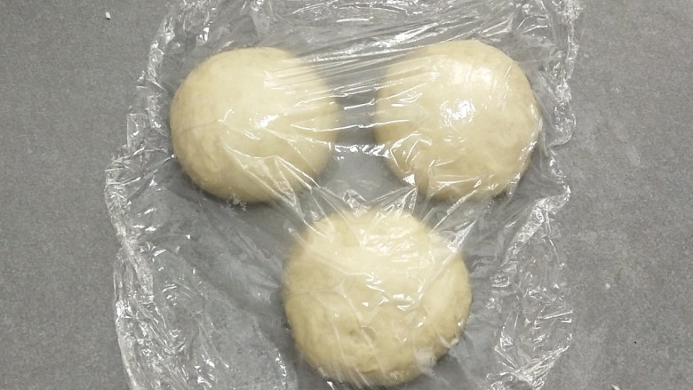 牛奶吐司,平均分成三份。滚圆,盖上保鲜膜松弛十分钟。