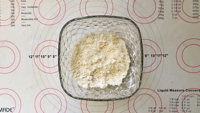 爆浆紫薯仙豆糕,现在开始制作面皮,把面皮中除了鸡蛋以外的所有材料放在碗中,用手搓成粗的颗粒。