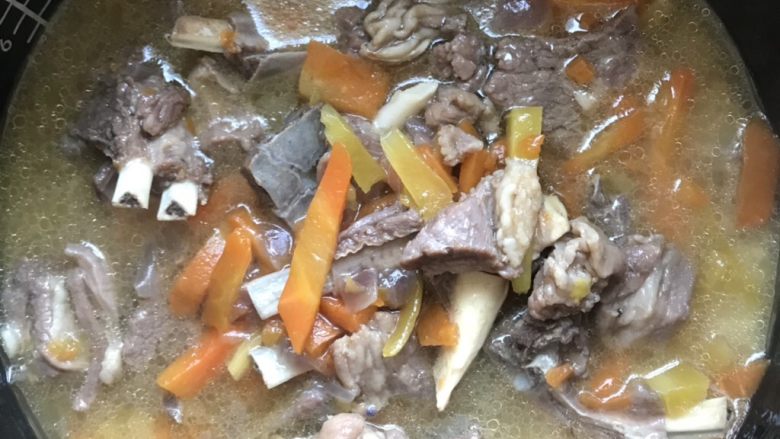 新疆抓饭,把泡好的米,羊肉、汤、放入电饭锅,稍微搅一下,正常蒸米饭,多焖5分钟。(这一步是用汤代替水,比平时蒸米饭少一点点汤,因为米是泡过的)