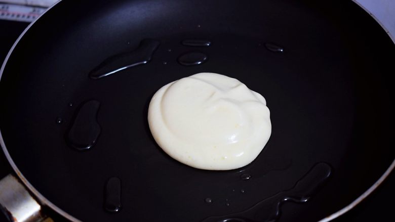 舒芙蕾松饼,平底锅烧至五六成热,舀入2勺面糊,再沿着面糊周围倒入1汤匙清水