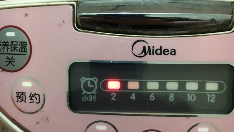 花生烧猪骨粥,按下电饭煲煲粥键,预约两小时